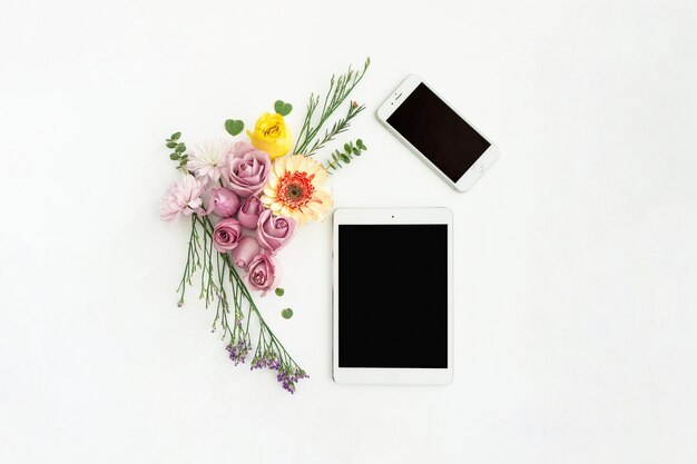 Tableta y móvil con flores decorativas