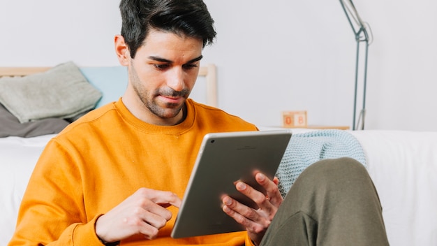 Foto gratuita tableta de navegación de hombre adulto