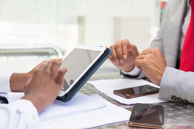 Tableta con pantalla en blanco en manos femeninas