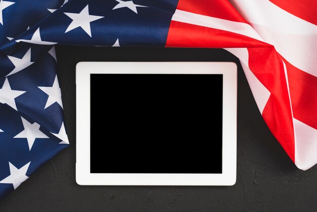 Tableta con pantalla vacía bordeando bandera americana