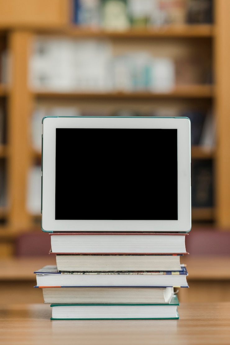 Foto gratuito tableta en la pila de libros