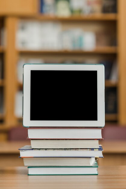 Tableta en la pila de libros