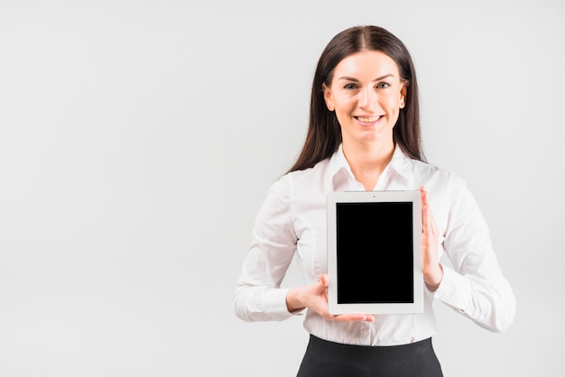 Tableta de la tenencia de la mujer de negocios con la pantalla en blanco