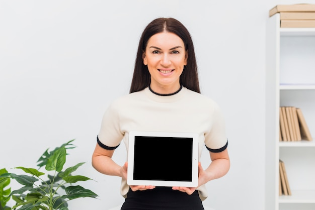 Tableta de la tenencia de la mujer con la pantalla en blanco