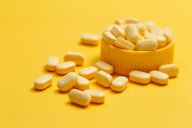 Tabletas de vitamina B sobre fondo amarillo