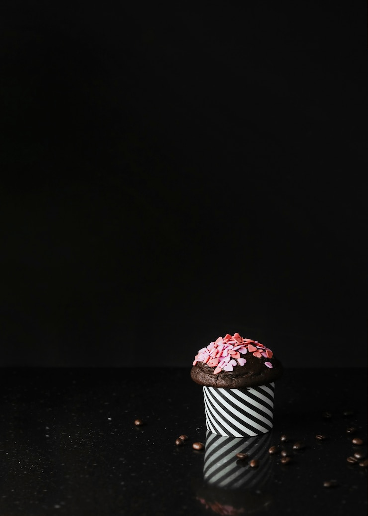 Photo Gratis taburan berbentuk hati pada cupcake dengan latar belakang hitam