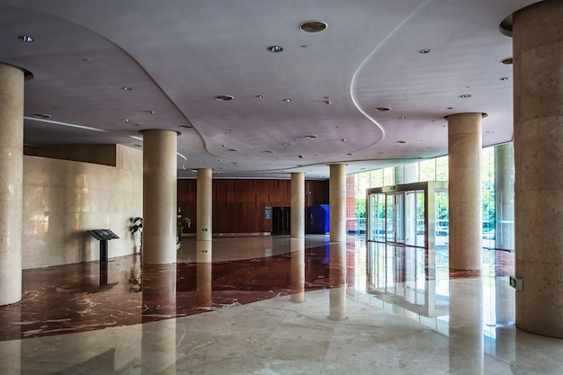 Taburetes elegantes y mesa en salón enorme y luminoso