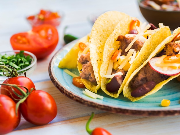 Foto gratuita taco en un plato cerca de los tomates