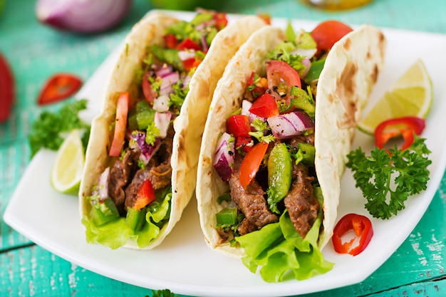 Tacos mexicanos con carne de res en salsa de tomate y salsa