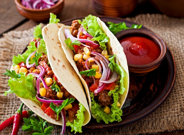 Tacos mexicanos con carne, verduras y cebolla roja.