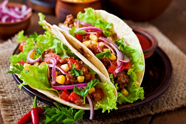 Tacos mexicanos con carne, verduras y cebolla roja.