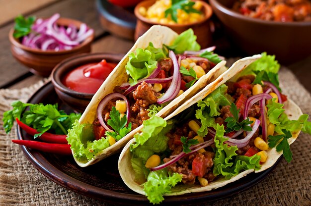 Tacos mexicanos con carne, verduras y cebolla roja.