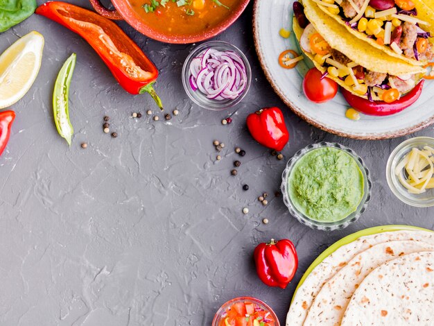 Tacos y quesadilla junto a tazas con verduras.