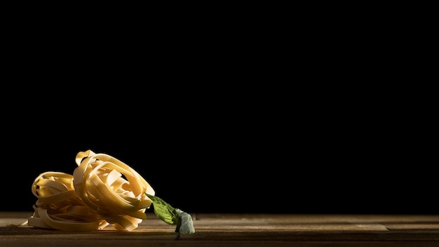 Foto gratuita tagliatelle con albahaca en el escritorio