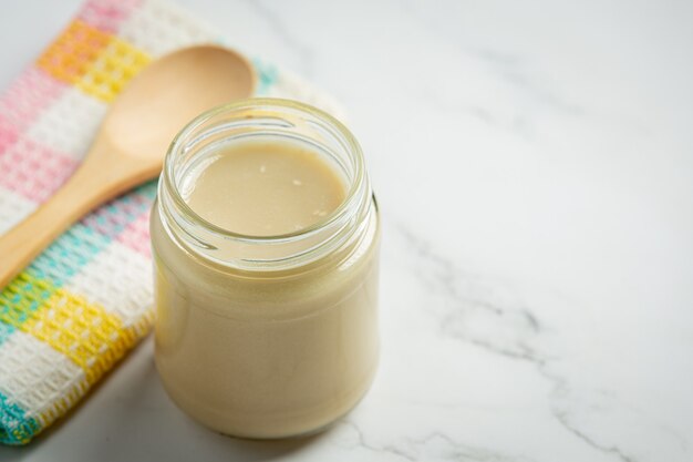 Tahini y semillas de sésamo sobre fondo de mármol