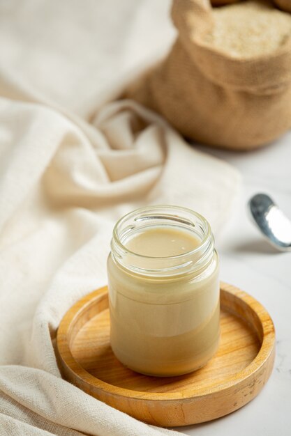 Tahini y semillas de sésamo sobre fondo de mármol