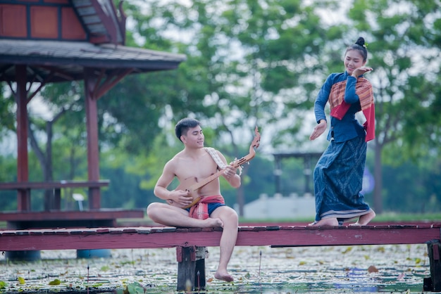 Tailandia mujeres y hombres en traje nacional con pin de guitarra (instrumento de cuerda pinchada)