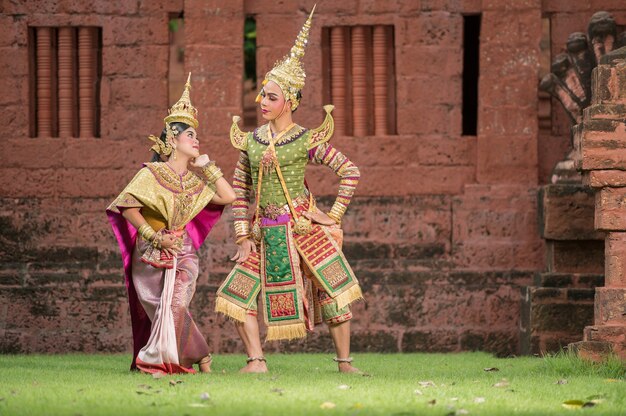 Tailandia Pareja de baile en representaciones de Khon enmascarado con templo antiguo