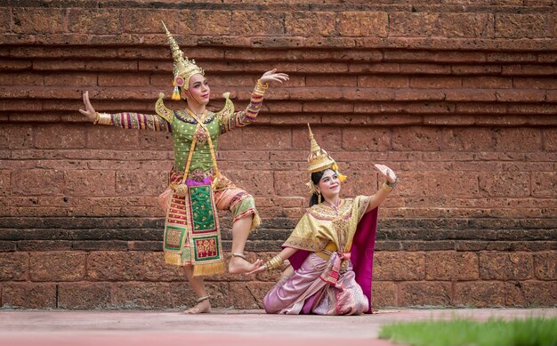 Tailandia Pareja de baile en representaciones de Khon enmascarado con templo antiguo