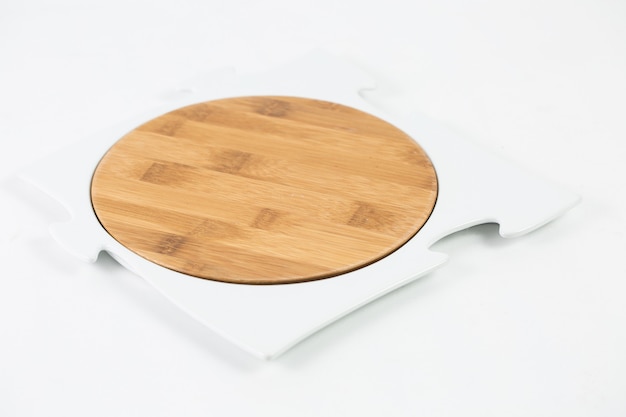 Tajadera de madera con un marco de rompecabezas aislado en una mesa blanca