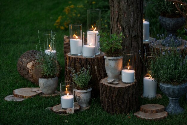 Tall vasos con velas blancas en los bloques en el jardín