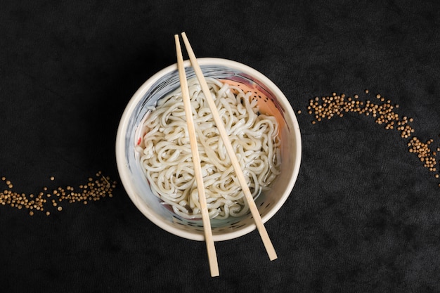 Los tallarines hechos en casa de udon de la comida japonesa con las semillas de coriandro diseñan en fondo negro