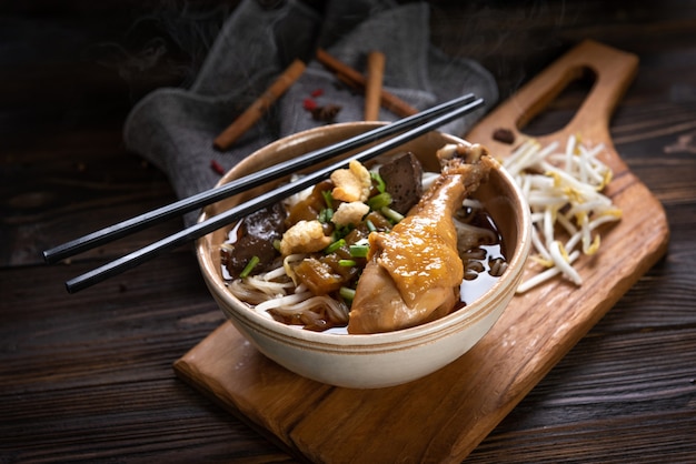 Tallarines con muslo de pollo y filete de pollo, sangre con sopa al estilo tailandés y verdura. Fideos de barco. Enfoque selectivo