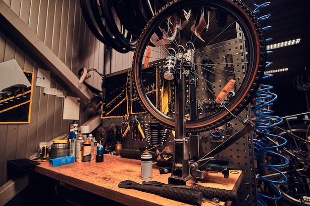 Taller ocupado con bicicleta de montaña rota sobre la mesa.