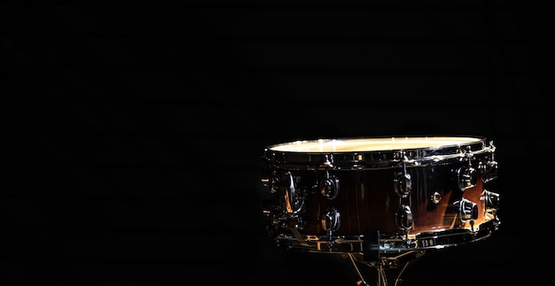 Foto gratuita tambor sobre un fondo negro, instrumento de percusión en la oscuridad, copie el espacio.
