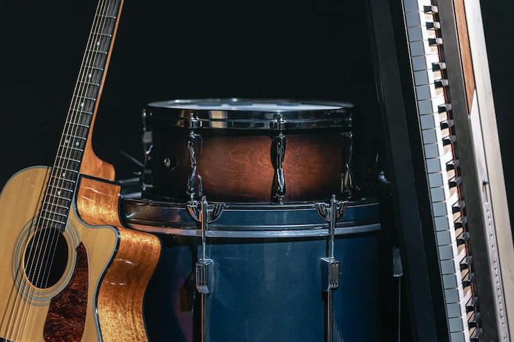 Foto gratuito tambores y teclas de guitarra acústica sobre un fondo negro