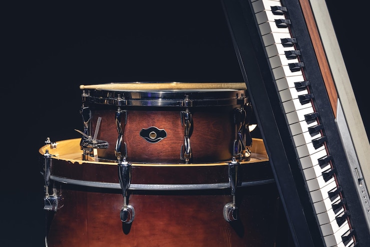 Foto gratuito tambores y teclas musicales en un fondo negro aislados