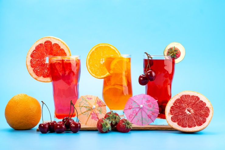 Photo Gratis tampak depan koktail buah segar dengan buah-buahan merah segar dan es citrus yang mendinginkan di atas biru, warna buah koktail jus minuman