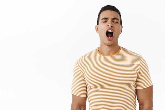 Foto gratuita tan cansado. varón masculino joven atractivo en camiseta rayada