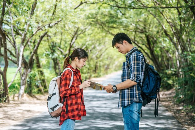 Tanto turistas masculinos como femeninos se paran a ver el mapa en el camino.