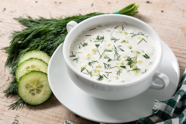 Tarator búlgara sopa de leche agria en un tazón sobre mesa de madera