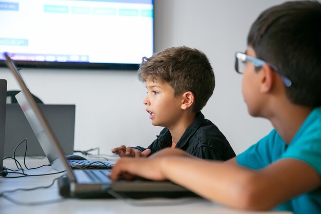 Foto gratuita tarea de lectura de niño caucásico en voz alta durante la lección