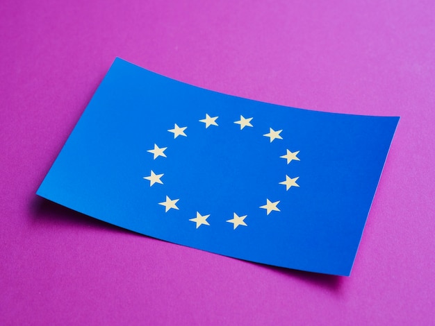 Foto gratuita tarjeta azul con bandera europea sobre fondo morado