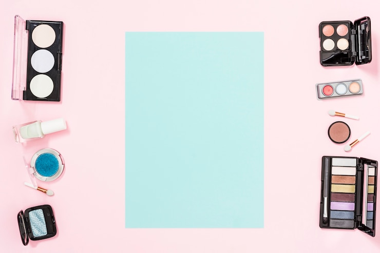 Foto gratuito tarjeta azul con espacio de copia para escribir el texto con productos cosméticos de maquillaje sobre fondo rosa