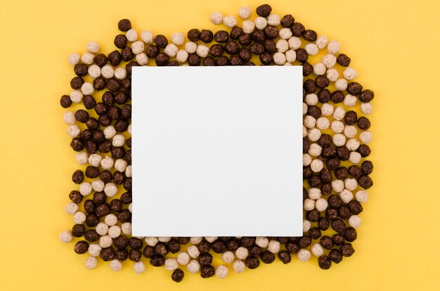 Tarjeta blanca con espacio de copia rodeado de cereales de chocolate