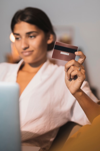 Tarjeta de crédito dorada sujeta por hermosa mujer