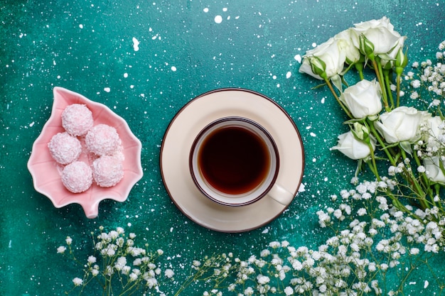 Tarjeta del día de la mujer del 8 de marzo con flores blancas, dulces y una taza de té