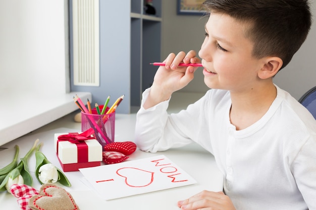 Tarjeta de escritura de hijo de alto ángulo para su madre