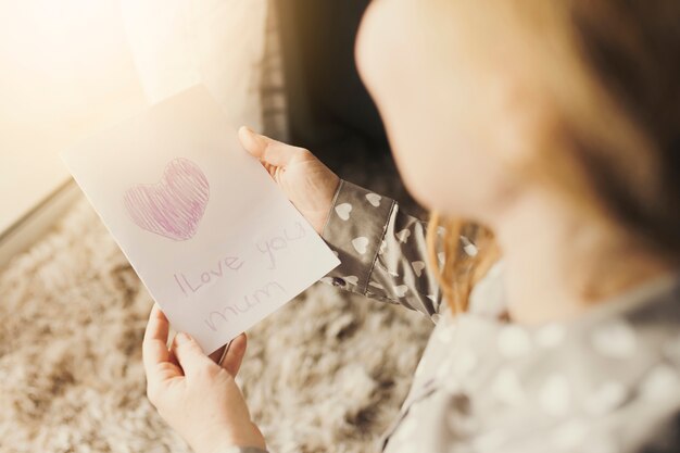 Tarjeta de felicitación de lectura de mujer con te amo inscripción de mamá