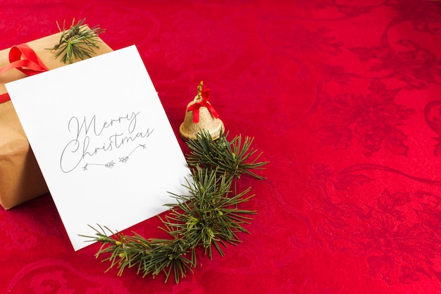 Foto gratuita tarjeta de felicitación de navidad en mesa roja