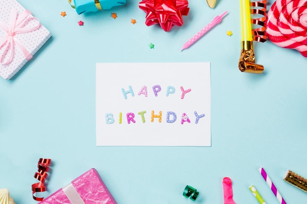 Foto gratuita tarjeta de feliz cumpleaños decorada con artículos sobre fondo azul