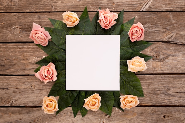 Foto gratuita tarjeta de invitación de boda con rosas en madera marrón antiguo.