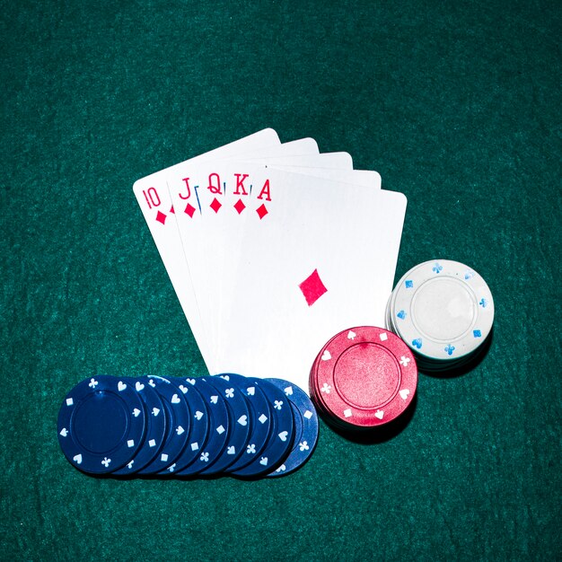Tarjeta de juego Royal Flush y fichas de casino en la mesa de póquer