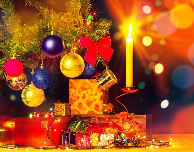 Tarjeta navideña de árbol de navidad y adornos. felices fiestas. objetos brillantes. cajas de regalo y luz de velas con guirnaldas.