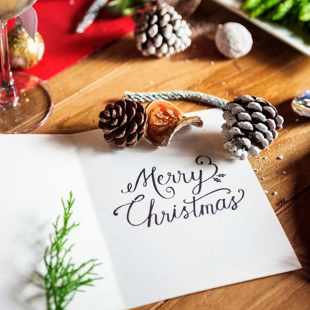 Tarjeta de la palabra feliz Navidad en mesa de madera celebración de vacaciones