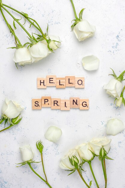 Tarjeta de primavera con rosas blancas y flores, vista superior